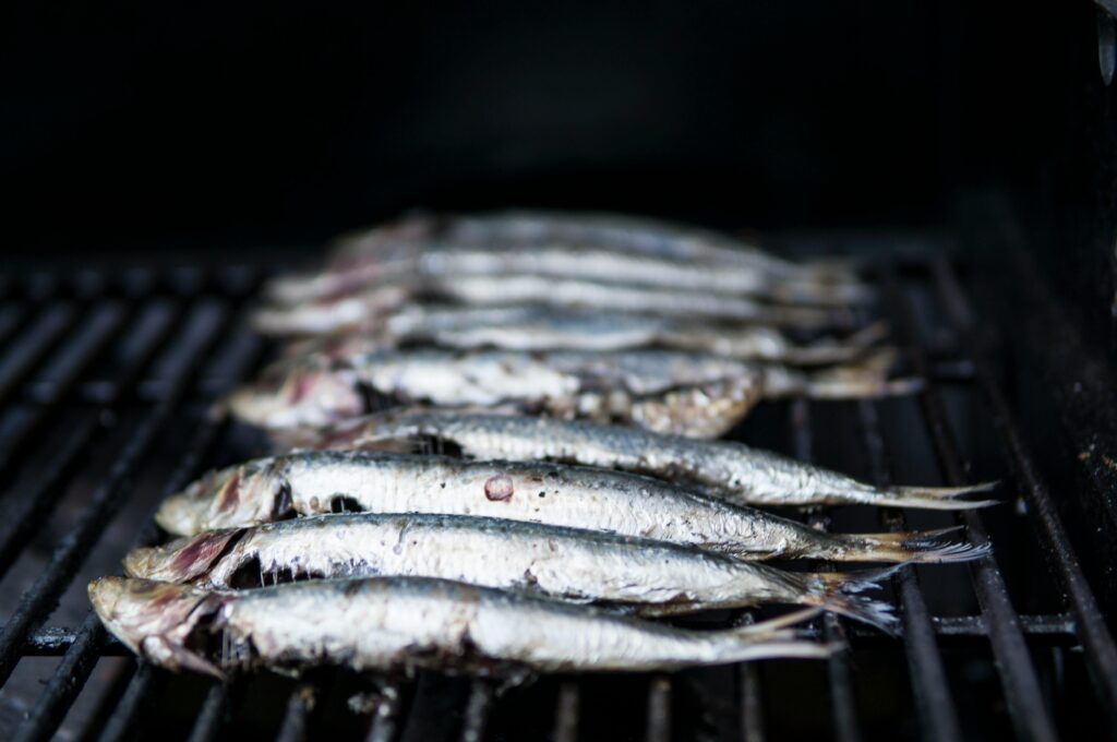 Close-up of sardines being grilled, perfect for healthy seafood cuisine.