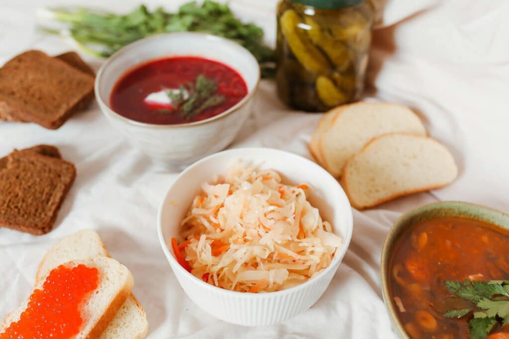 A diverse spread featuring Russian foods like borscht, sauerkraut, and caviar on a table.